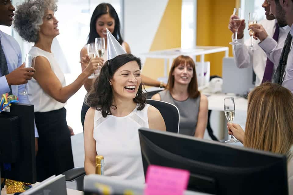 employees at an office party toasting champagne glasses