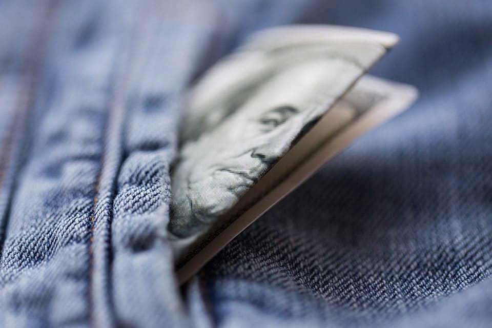 100 dollar bill with Benjamin Franklin's face inside a jean pocket